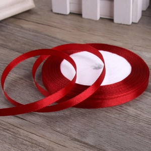Vibrant 6mm red satin ribbon roll for gift wrapping and DIY crafts on wooden surface