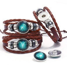 Detail view of woven brown leather bracelet with glowing snap button buckle