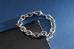Detail of silver stainless steel chain bracelet with lobster clasp on leather wallet