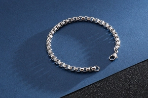 Detailed close-up of a silver stainless steel box chain bracelet with lobster clasp