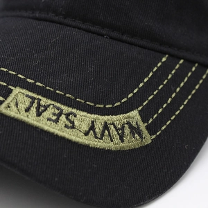 Détail de la broderie Navy Seal et des coutures vertes sur la visière en coton noir