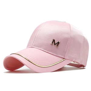 Detail of pink satin baseball cap with golden M logo and metallic edge stitching
