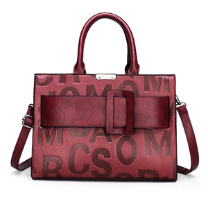 Elegant burgundy leather tote bag with embossed letter texture and decorative buckle detail