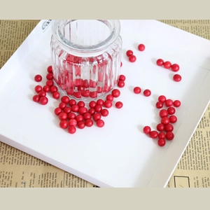 Artificial red holly berries decoration for DIY crafts in a vintage glass jar setting