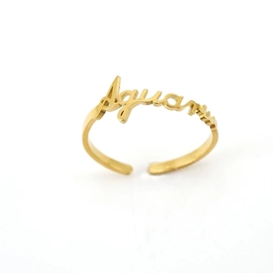 Detail of gold Aquarius zodiac ring featuring cursive script and an adjustable band