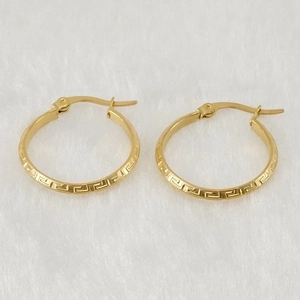 Pendientes de aro en acero inoxidable chapado en oro 18K con patrón griego sobre piel blanca