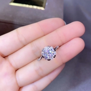 Sparkling round moissanite cluster ring with twisted band and accent stones on hand