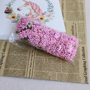 Vue détaillée de grappes de baies artificielles roses pour décorations florales DIY
