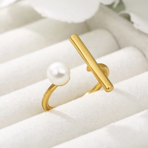 Macro shot of 18k gold plated open ring with white pearl on white velvet display