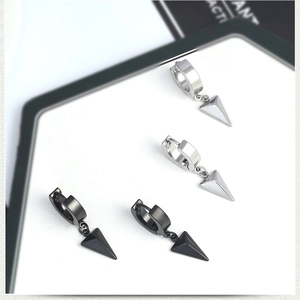 Close-up of silver and black stainless steel hoop earrings with 3D pyramid pendants