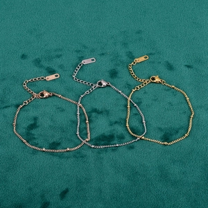 Detailed macro view of 18K gold dainty bead bracelets with lobster clasps and k18 tags