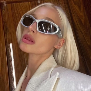 Futuristic Y2K silver wrap sunglasses with streamlined frames on a fashion model