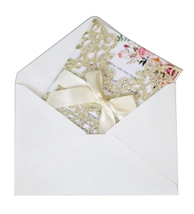 Detail of dark green glitter laser-cut wedding invitation with beige ribbon bow and card