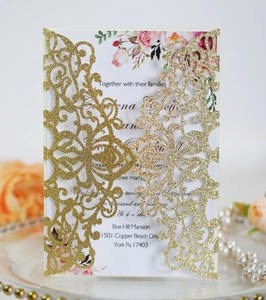 Detail of laser-cut gold glitter wedding invitation with pink floral inner card and roses