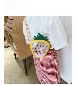 Detail of strawberry-shaped child crossbody bag with sparkling sequins and glitter filling