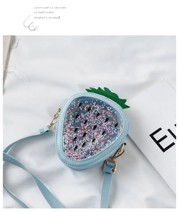 Close-up of strawberry-shaped child bag in light blue with glitter sequins detail