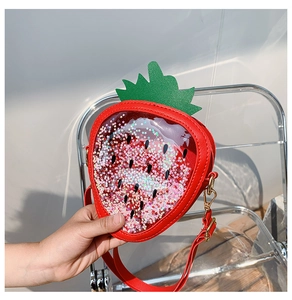 Close-up of strawberry shape bag with colorful star sequins and red adjustable strap