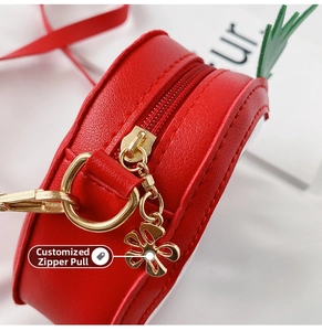 Detail of red strawberry bag with lychee texture and gold flower zipper puller