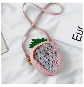 Close-up of pink strawberry sequin bag with green leaf detail and gold hardware