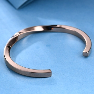 Macro shot of rose gold plated twisted titanium steel bangle with polished mirror finish