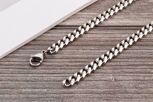 Macro detail of polished silver cuban link chain body jewelry with secure lobster clasp