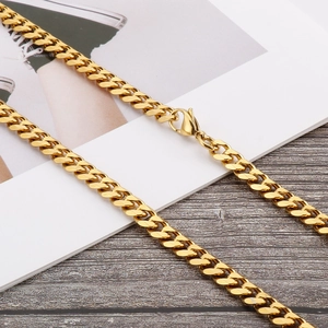Trendy gold titanium steel flat Cuban link chain necklace with lobster clasp on a desk