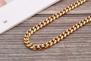 Close-up of golden flat Cuban link chain with glossy polished finish on wood surface