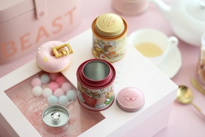 Detailed view of mini tinplate tea canisters with double lids and bunny illustrations
