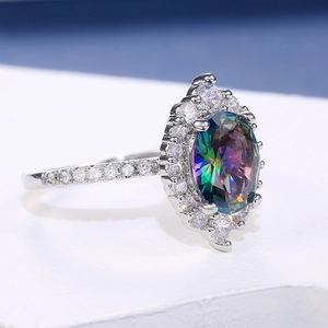 Macro shot of oval rainbow topaz ring with halo zircon setting and pave band details