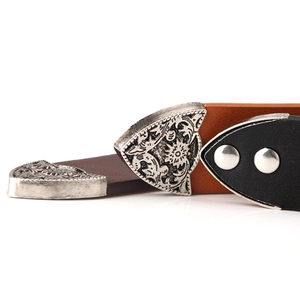 Vintage leather belts in black and tan featuring ornate engraved silver floral metal tips