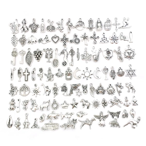 Flat lay of diverse antique silver charms including animals, leaves and cross shapes