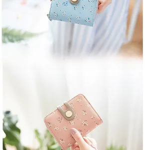 Detail of floral printed women's short wallets in pink and blue with snap closure