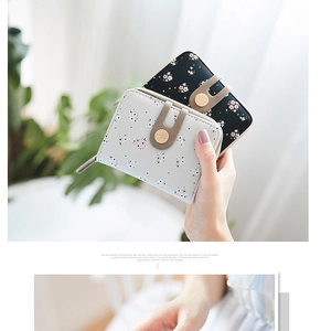 Detail of floral printed small wallets with zip and buckle closure in grey and black