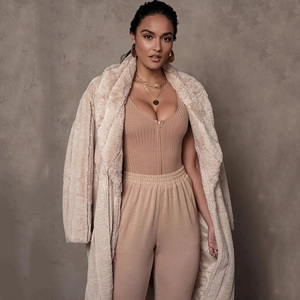 Detail view of the beige ribbed zip-up bodysuit paired with a matching plush coat