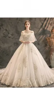 Detailed embroidery of gold floral lace and sequins on off-shoulder bridal gown