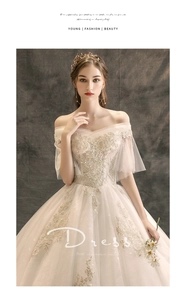 Detail showing off-the-shoulder ivory lace embroidery and mesh sleeves of wedding dress