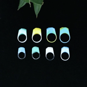 Flat lay of geometric resin rings in various colors on a black velvet surface