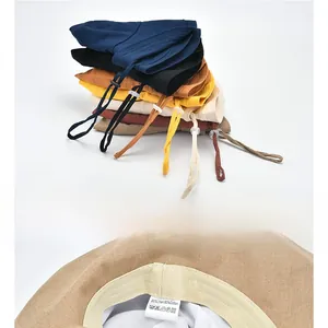 Detail showing 20% linen 80% cotton label and adjustable windproof rope on sun hat