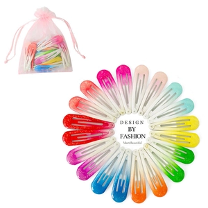 Radial layout of colorful gradient hair clips with glitter finish and pink mesh pouch