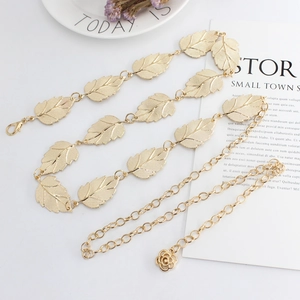 Elegant gold leaf metal chain belt for dresses with rose pendant on a clean white surface