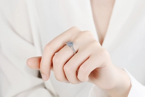 Close-up of a S925 sterling silver halo moissanite ring worn on a finger