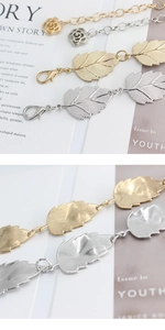 Close-up of gold and silver leaf charms with rose connectors on elegant metal waist chains