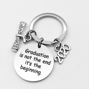 Macro detail of silver graduation keychain with engraved 2020 charm and quote pendant