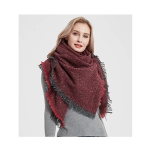 Close-up of red and grey mixed knit scarf featuring thick fringe details and soft texture