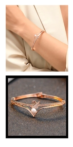 Detail of rose gold swan bangle with pavé crystals and white pearl accent