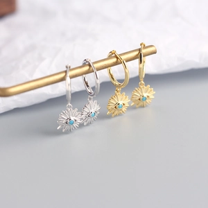 Macro view of gold and silver S925 sterling silver sun eye earrings with turquoise beads