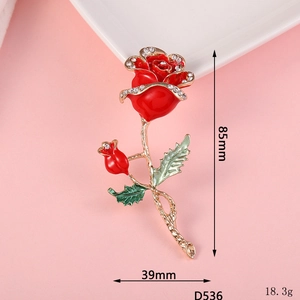 Detail view of red enamel rose brooch with dimensions 85mm by 39mm and crystal accents