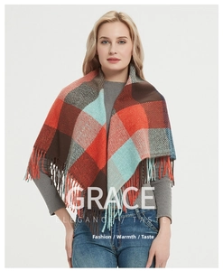 Détail d'un grand châle à carreaux d'hiver avec franges en orange et bleu vif