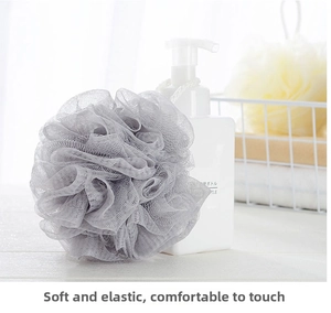 Detail of soft grey mesh bath sponge with white rope hanging in a clean bathroom