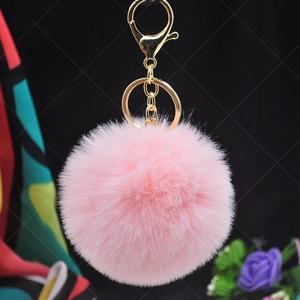 Pink 8cm faux rabbit fur pom pom keychain with gold lobster clasp and ring on dark background
